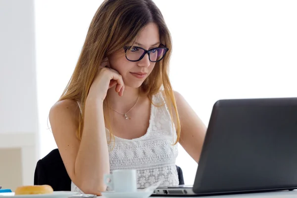 Mooie jonge vrouw met behulp van haar laptop thuis. — Stockfoto