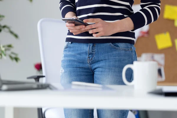 Mujer joven y segura que trabaja en su oficina con teléfono móvil . —  Fotos de Stock