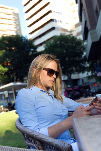 Mulher bonita usando seu telefone celular em um restaurante ter — Fotografia de Stock