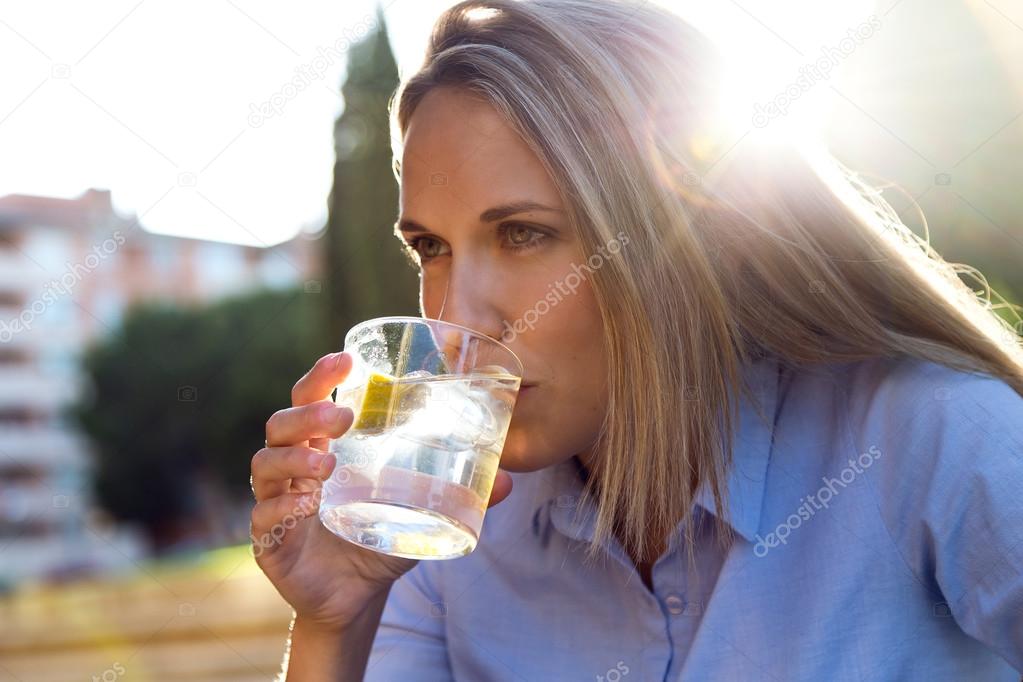 Beautiful young woman drinking soda in a restaurant terrace.