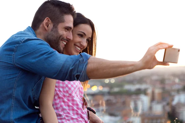 Jovem casal de turistas na cidade usando telefone celular . — Fotografia de Stock