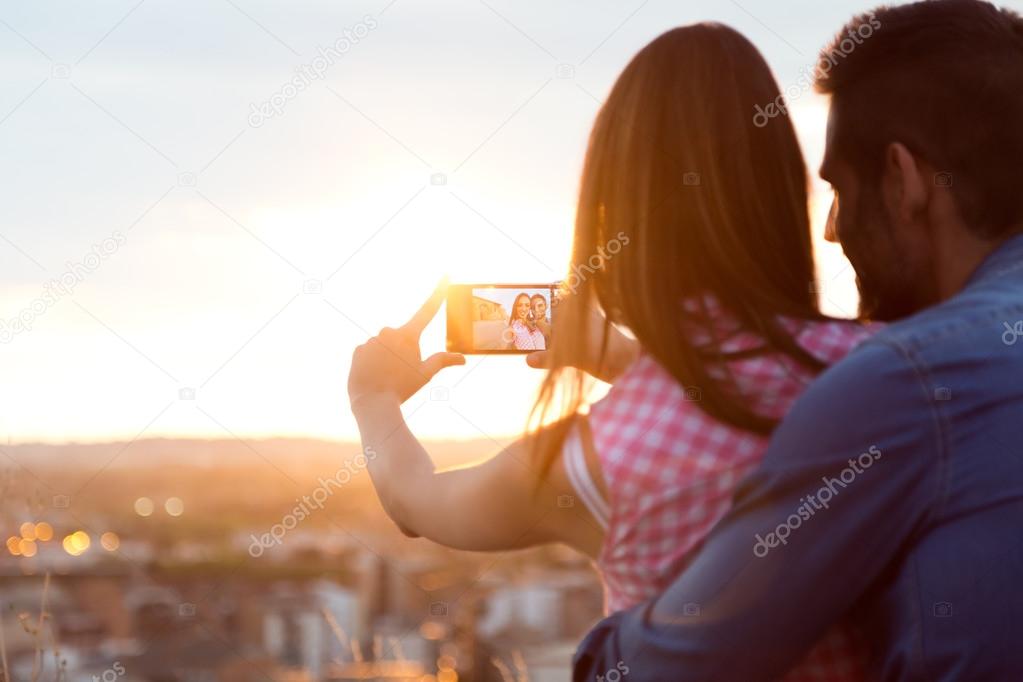 Young couple of tourist in town using mobile phone. 