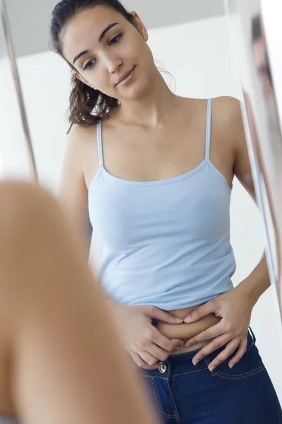 Beautiful young woman measuring fat level on her abdominal. — Stock Photo, Image