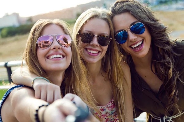 Beautiful young women using mobile phone in the street. — Stock Photo, Image