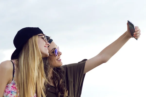 Hermosas mujeres jóvenes utilizando el teléfono móvil en la calle . —  Fotos de Stock