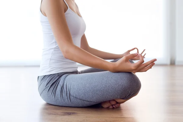 Mooie jonge vrouw doen yoga oefeningen thuis. — Stockfoto