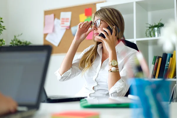 Geschäftsfrau arbeitet mit Handy in ihrem Büro. — Stockfoto