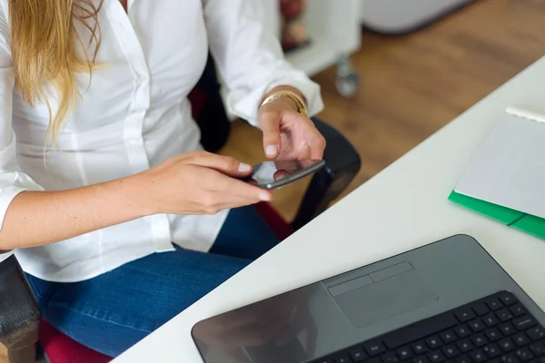 Biznes kobieta pracuje z telefonu komórkowego w jej biurze. — Zdjęcie stockowe