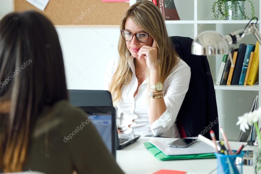 Two business woman working in her office.