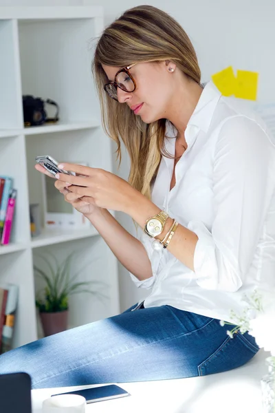 Mujer de negocios que trabaja con teléfono móvil en su oficina . — Foto de Stock