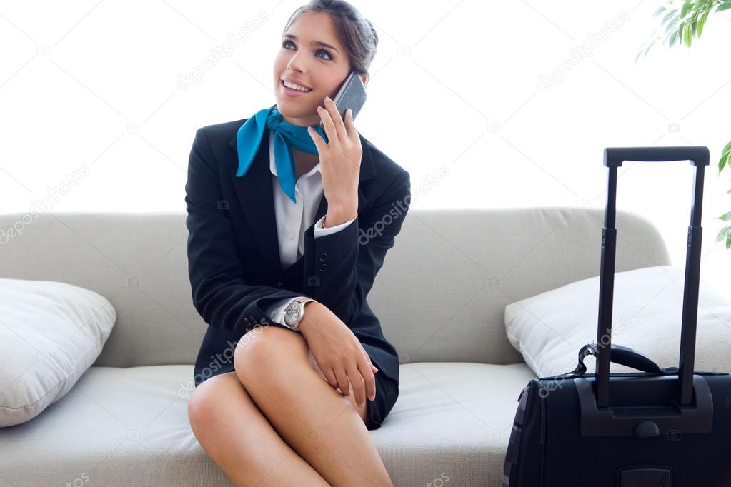 Beautiful hostess in airport with mobile phone.
