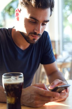 Cep telefonu kafede ile modern genç adam.