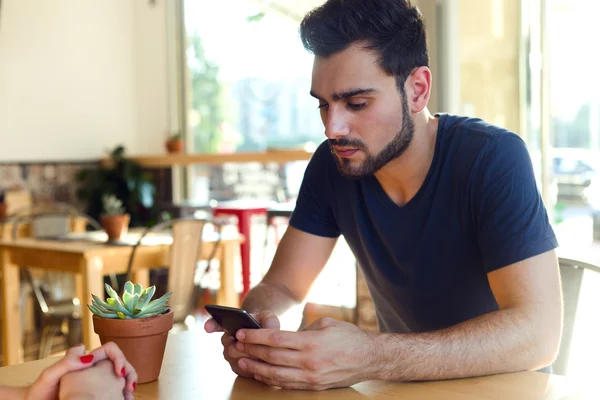 Modern young man with mobile phone in cafe. — Stock Photo, Image