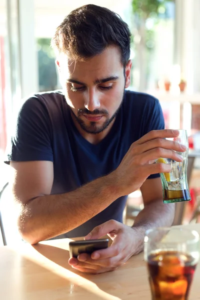 Modern young man with mobile phone in cafe. — Stock Photo, Image