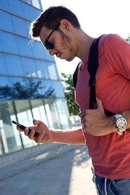 Yakışıklı genç adam sokakta cep telefonunu kullanma.