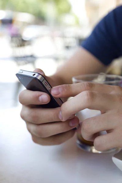 Knappe jongeman met behulp van zijn mobiele telefoon in de straat. — Stockfoto