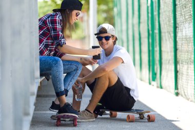 Cep telefonuyla sokakta iki patenciler.