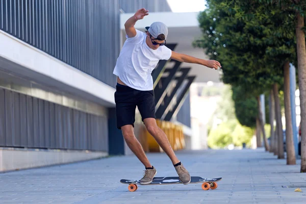 Guapo joven skateboarding en la calle . — Foto de Stock