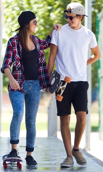 Młoda para skateboardingu na ulicy. — Zdjęcie stockowe