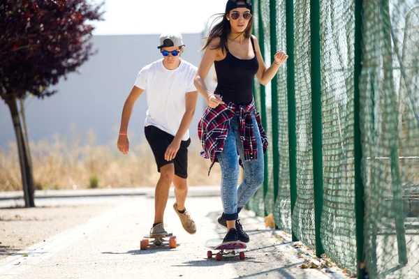 Junges Paar skateboardet auf der Straße. — Stockfoto
