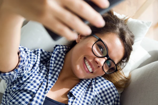 Mooie jonge vrouw die een selfie thuis. — Stockfoto