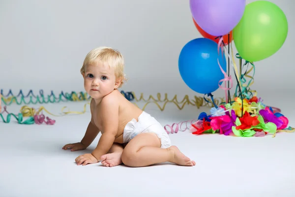 Baby girl celebrating her first birthday with gourmet cake and balloons. — Stock Photo, Image