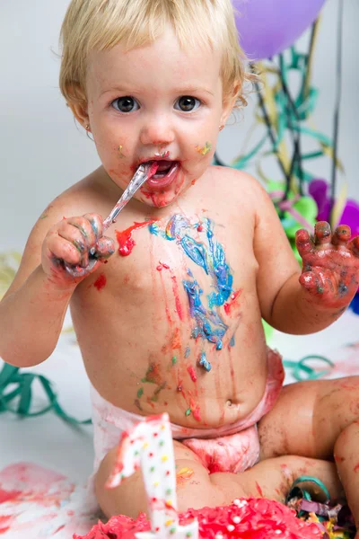 Baby girl celebrating her first birthday with gourmet cake and balloons. — Stock Photo, Image