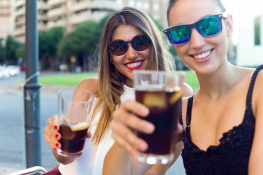 Güzel genç kadın sokakta ferahlık içme.