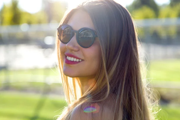 Retrato de moda de una joven linda y sonriente en la calle . — Foto de Stock