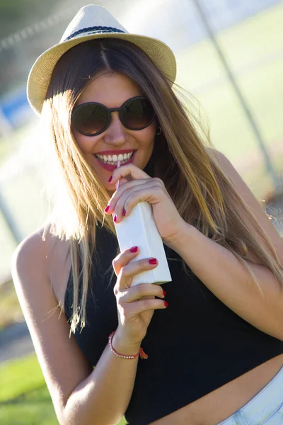 Retrato de bela jovem mulher bebendo suco na rua . — Fotografia de Stock