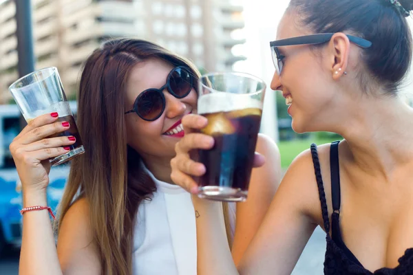 Schöne junge Frauen trinken Erfrischung auf der Straße. — Stockfoto
