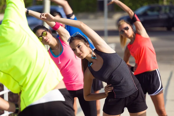 Portrait of running people doing stretching in the park. — Stock Photo, Image