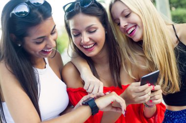 Üç kız parkta onların akıllı telefonlar ile sohbet.