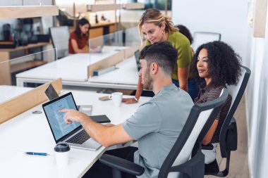 İşadamlarının dizüstü bilgisayarla çalışmalarını ve birlikte çalıştıkları bir yerde yeni projelerinden bahsetmelerini.