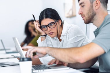 İşadamlarının dizüstü bilgisayarla çalışmalarını ve birlikte çalıştıkları bir yerde yeni projelerinden bahsetmelerini.