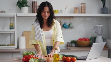 Evde mutfakta sağlıklı salata hazırlarken taze sebze kesen güzel bir kadının videosu..