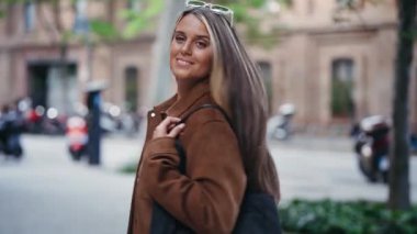 Şehirde yürürken akıllı telefonunu kullanan güzel bir kadının videosu.