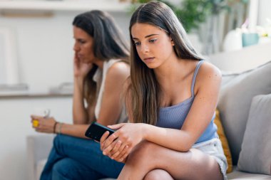 Evdeki kanepede otururken akıllı telefonu bırakmadığı için kızını azarladıktan sonra üzgün bir anne vuruldu.