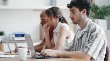 Birlikte çalıştığı yerde dizüstü bilgisayarlarla çalışan başarılı iş ekibinin videosu.