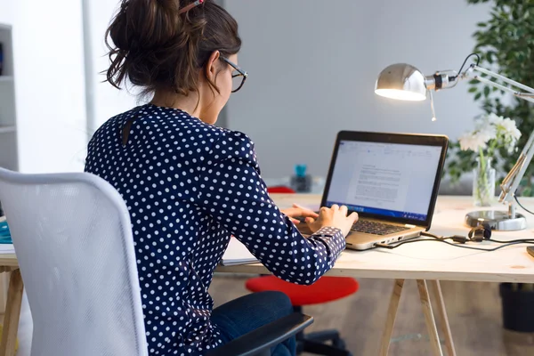 아름 다운 젊은 여 자가 그녀의 사무실에서 노트북으로 작업. — 스톡 사진