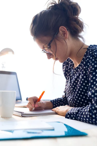 Vacker ung kvinna som arbetar på sitt kontor. — Stockfoto