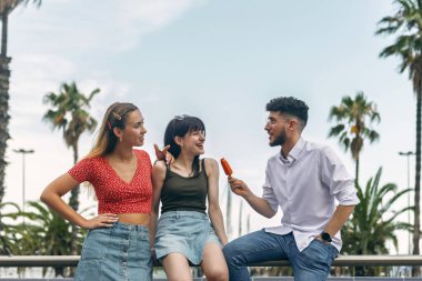 Yazın şehri gezerken gülümseyen ve eğlenen arkadaşlar.