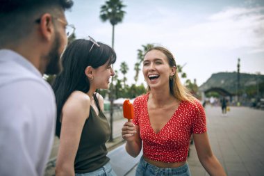 Yazın şehri gezerken gülümseyen ve eğlenen arkadaşlar.