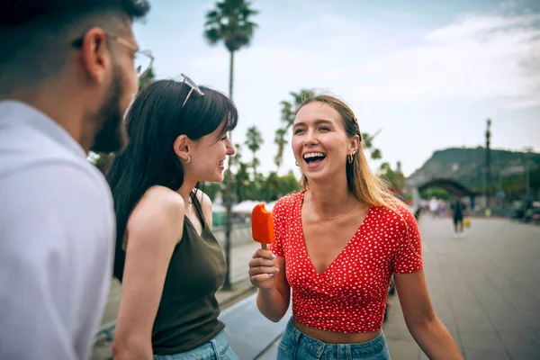 Yazın şehri gezerken gülümseyen ve eğlenen arkadaşlar.