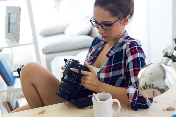 Młoda kobieta fotograf sprawdzanie Podgląd na aparat w sworzniu — Zdjęcie stockowe