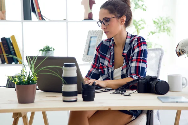 Mladá podnikatelka v její kanceláři s notebookem. — Stock fotografie