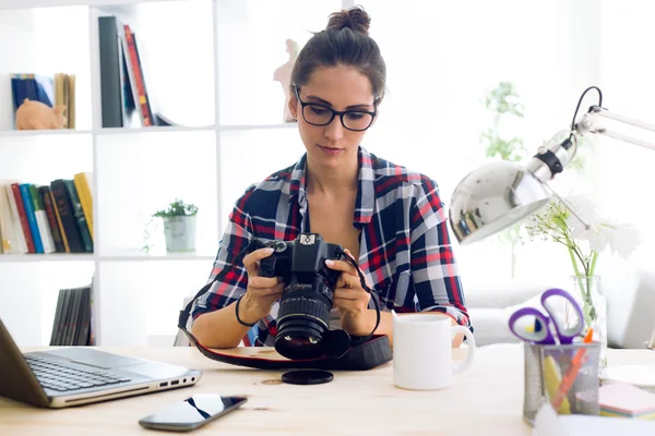 Młoda kobieta fotograf sprawdzanie Podgląd na aparat w sworzniu — Zdjęcie stockowe