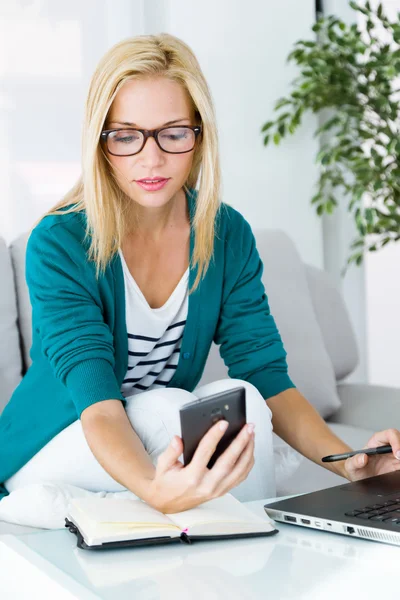 Jolie jeune femme qui travaille et utilise son téléphone portable . — Photo