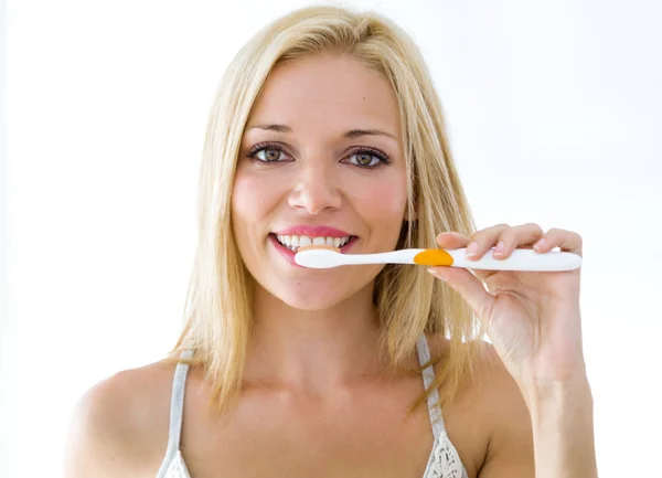 Mulher loira muito jovem limpando os dentes . — Fotografia de Stock