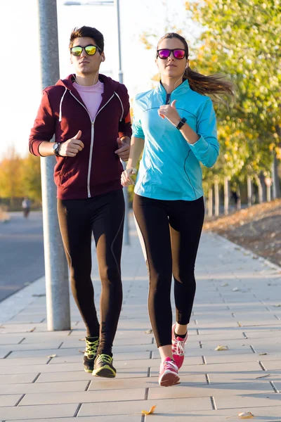 Beautiful couple running in the street. — Stock Photo, Image